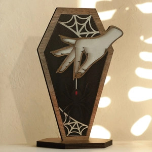 Close-up of gothic wooden coffin decor with spooky hand, spider and cobweb details
