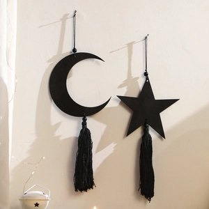Detail of bohemian black crescent moon and star wooden wall hanging with long fringe tassels