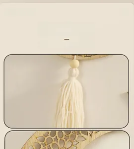 Detail of wooden wall hanging featuring moon cutout and white cotton tassels decoration