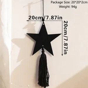 Detail view of black moon and star wooden hanging decor with long tassels for wall