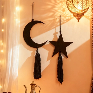 Detail of black moon and star wooden hanging ornaments with tassels in a warm room setting