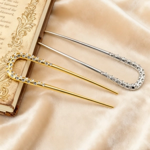 Détails macro d'épingles à cheveux en U or et argent avec accents de strass brillants