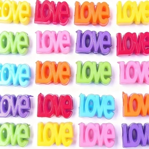 Vue macro de perles en acrylique colorées en forme de love pour tresses DIY