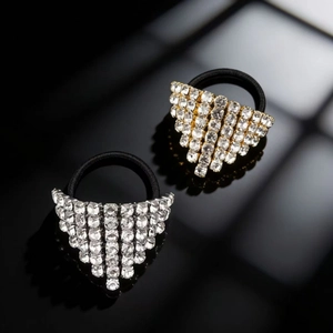 Primo piano di elastici per capelli con strass a triangolo in oro e argento su riflesso