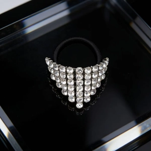 Dettaglio della nappa di strass triangolari su un elastico per capelli nero elegante