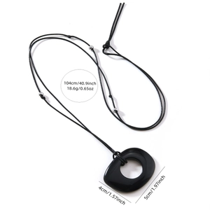 Minimalist long black rope necklace with obsidian pendant and silver beads on white background