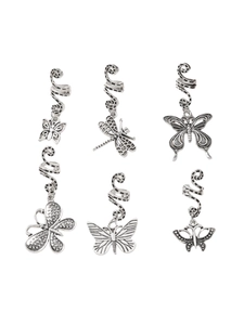 Close-up of vintage silver spiral hair rings featuring dragonfly and butterfly charms