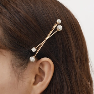 Chic gold-tone cross bobby pin hair clips with sparkling rhinestone spheres on brown hair