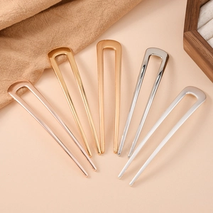 Classic U-shaped metal hairpins in five metallic shades displayed on a beige background