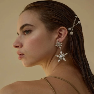 Close-up of star drop earrings and silver pearl bobby pins on a model with wet hair