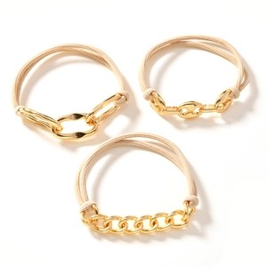 Drei beige elastische Haargummis mit goldenen Metallketten und Schweinenasen-Design