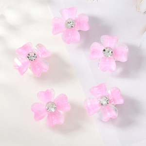Nahaufnahme von rosa Blumen-Haarspangen mit Glitzerblättern und Strasssteinen