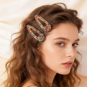 Barrettes à cheveux en strass colorés en forme de goutte portées par un mannequin