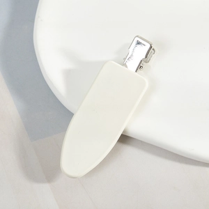 Vue détaillée d'une barrette à cheveux blanc crème avec une pince croco en métal argenté