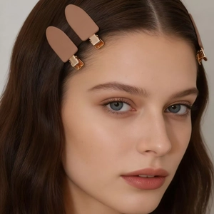 Barrettes à cheveux mates aux tons marrons portées par un mannequin pour un look chic