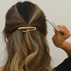 Close-up of minimalist gold and silver alloy hair clips worn in a half-up hairstyle