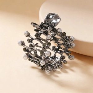 Close-up of vintage gunmetal hair claw with white pearls and grey rhinestones detail