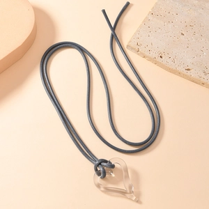 Minimalist transparent resin heart pendant necklace with long grey cord on warm stone