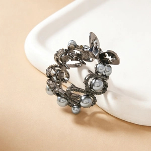Gothic butterfly hair clip with gray pearls and dark rhinestones on ceramic tray