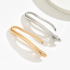Minimalist fluid wave metal hair clip in gold and silver finish with sleek wavy design