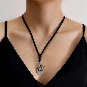 Minimalist black rope necklace with silver oval pendant and spring clasp on model
