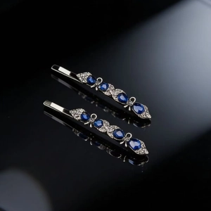 Detail view of vintage silver bobby pins with blue teardrop gems and bow design