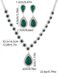 Détail d'une parure de bijoux de mariée avec cristaux émeraude et motifs floraux argentés