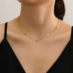 Collana minimalista dorata con cinque piccoli ciondoli a stella a quattro punte