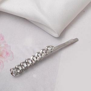 Macro view of silver-plated hair clip with interlocking chains and sparkling rhinestones