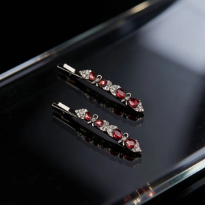 Elegant silver hair clips with red marquise gems and white rhinestones on black background