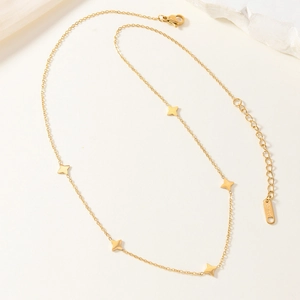 Collana in acciaio inossidabile dorato con cinque pendenti a stella su sfondo minimalista
