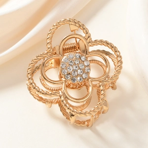 Elegant gold flower hair claw clip with rhinestones on silk background