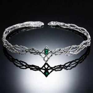 Detail of silver fantasy elven crown with vine textures and a teardrop green gemstone