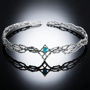 Macro detail of a silver elf tiara with branch textures and a blue teardrop gemstone