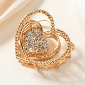 Detail of golden heart hair claw clip with rope texture and sparkling rhinestones