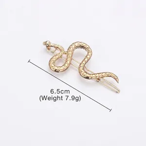 Golden snake-shaped metal hair clip with detailed scale texture and S-curve design
