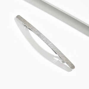 Minimalist silver zinc alloy hair clip with irregular textured finish on white background