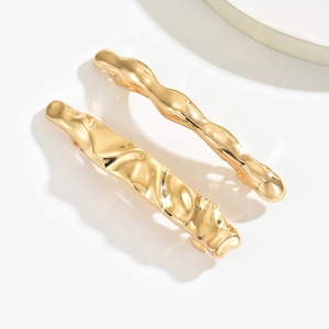 Set of two gold irregular lava style hair clips with polished metallic wavy texture
