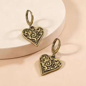 Boucles d'oreilles cœur vintage en bronze avec motifs filigranes sur présentoir