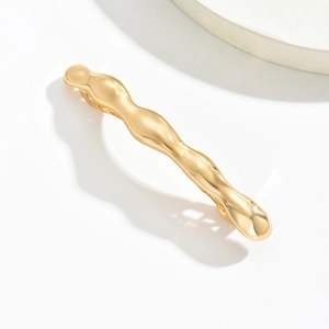 Detailed view of large gold wave-shaped alloy hair claw clip with a polished mirror finish