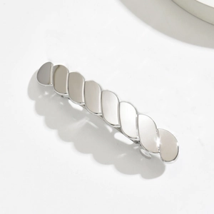 Macro detail of silver twisted metal hair claw with polished mirror finish texture