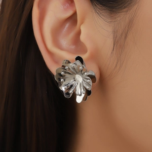 Boucles d'oreilles camélia argentées de style français portées sur l'oreille