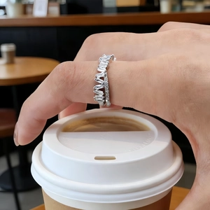 Gros plan d'une bague croisée élégante avec oxydes de zirconium à la main
