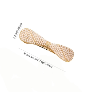 Bowknot hair clip with sparkling pearls and gold metal base measuring 9cm in length