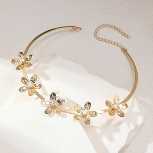 Vista detallada de un collar tipo gargantilla dorado con flores y piedras blancas brillantes