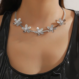 Primer plano de un collar choker de plata con flores de cinco pétalos y cristales brillantes