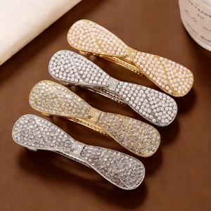 Bow hair clip set with sparkling rhinestones and imitation pearls in gold and silver finish