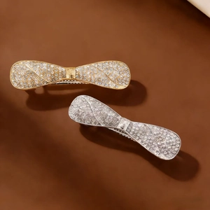 Macro shot of gold and silver bow hair clips featuring sparkling crystal rhinestones inlay