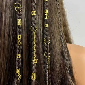 Détail de bagues de cheveux dorées lune et étoile sur tresses avec texture évidée