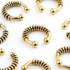 Detail of vintage gold spiral texture horseshoe rings with round ball ends for jewelry
